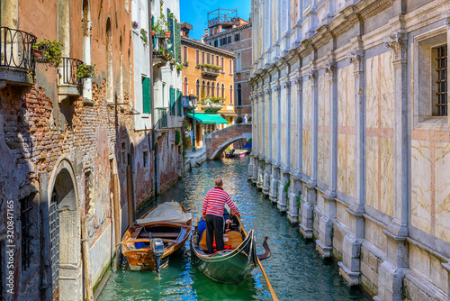 Narrow canal with gondola and bridge in Venice, Italy. Architecture and landmark of Venice. Cozy cityscape of Venice. © Ekaterina Belova