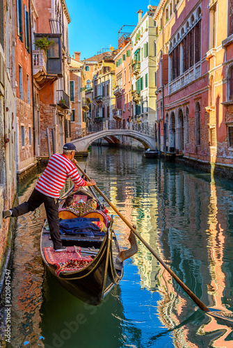 Narrow canal with gondola and bridge in Venice, Italy. Architecture and landmark of Venice. Cozy cityscape of Venice. © Ekaterina Belova