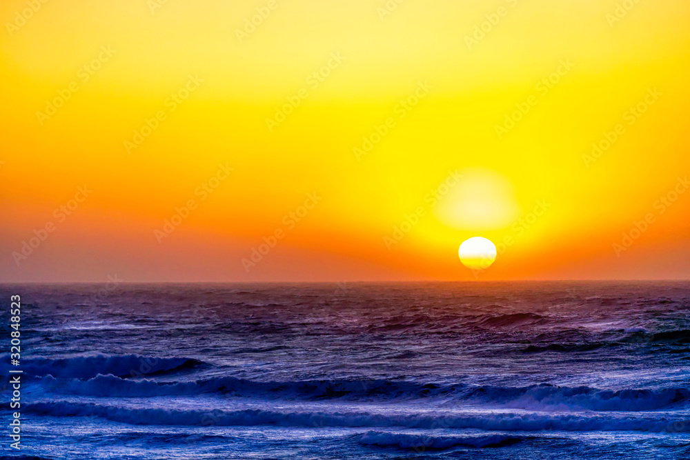 Yellow Sun setting over Ocean 