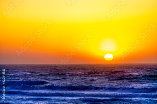 Yellow Sun setting over Ocean 