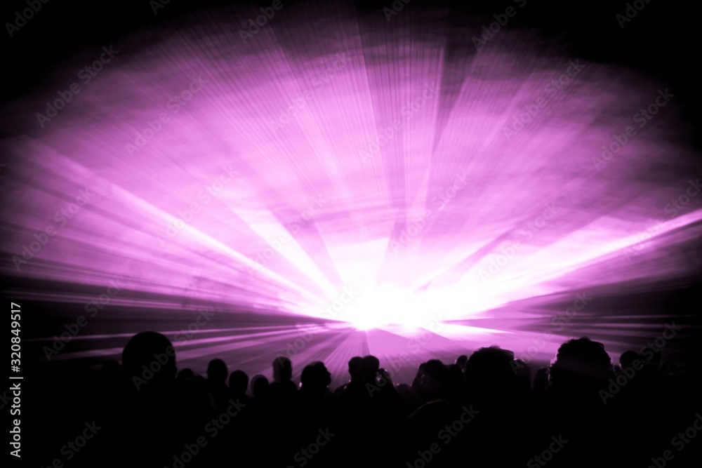 Pink laser show nightlife club stage with party people crowd. Luxury entertainment with audience silhouettes in nightclub event, festival or New Years Eve. Beams and rays shining colorful lights