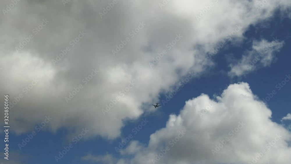 Airplane flying through the clouds above Hawaii, ground view Airplane flying through the clouds above Hawaii, ground view