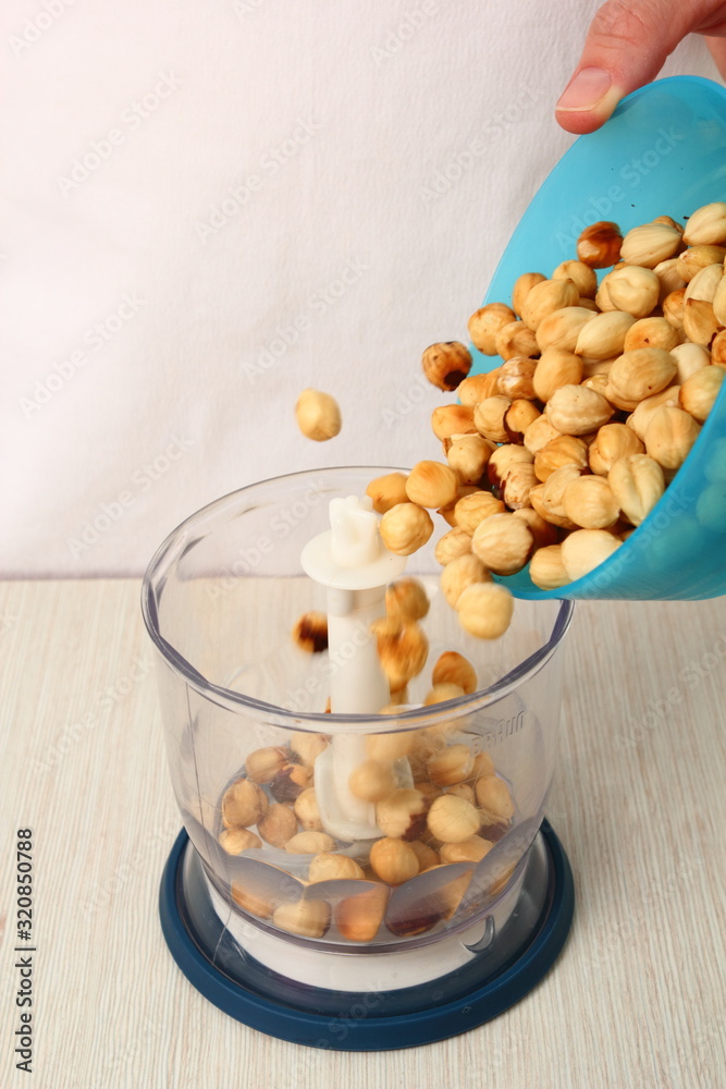 Pour hazelnuts into mixer bowl. Making Chocolate Hazelnut Meringue Cake. Pour hazelnuts into mixer bowl. Making Chocolate Hazelnut Meringue Cake.