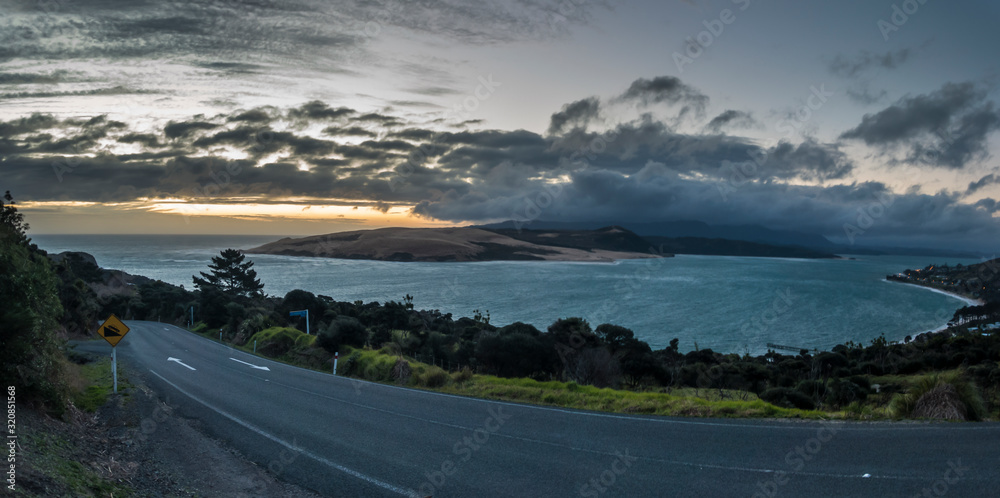 Asphalt coastal road with ocean during sunset