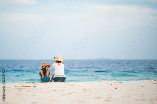 砂浜に座って話す母と娘 © hakase420