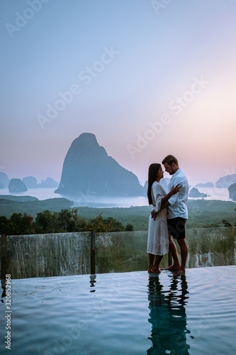 Phanga bay viewpoint, couple watching sunrise on the edge of a swimming pool, infinity pool looking out over Phangnga Bay Thailand photo