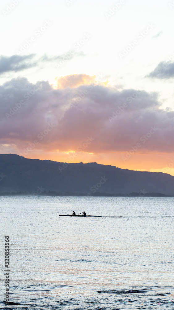 Outrigger canoes at sunset at Haleiwa Hawaii Oahu orange clouds with blank space for copy Outrigger canoes at sunset at Haleiwa Hawaii Oahu orange clouds with blank space for copy