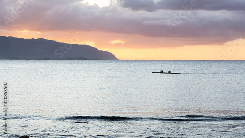 Valokuva Outrigger canoes at sunset at Haleiwa Hawaii Oahu orange clouds with blank space