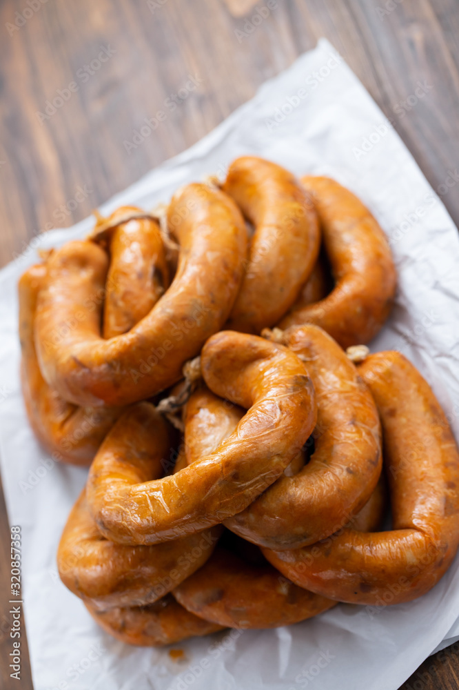 portuguese smoked sausages alheira on white paper on ceramic background portuguese smoked sausages alheira on white paper on ceramic background