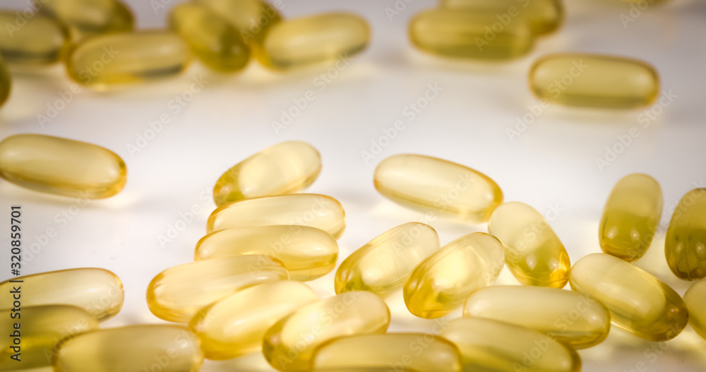 Fish Oil Omega 3 golden capsules on black blackground Fish Oil Omega 3 golden capsules on black blackground