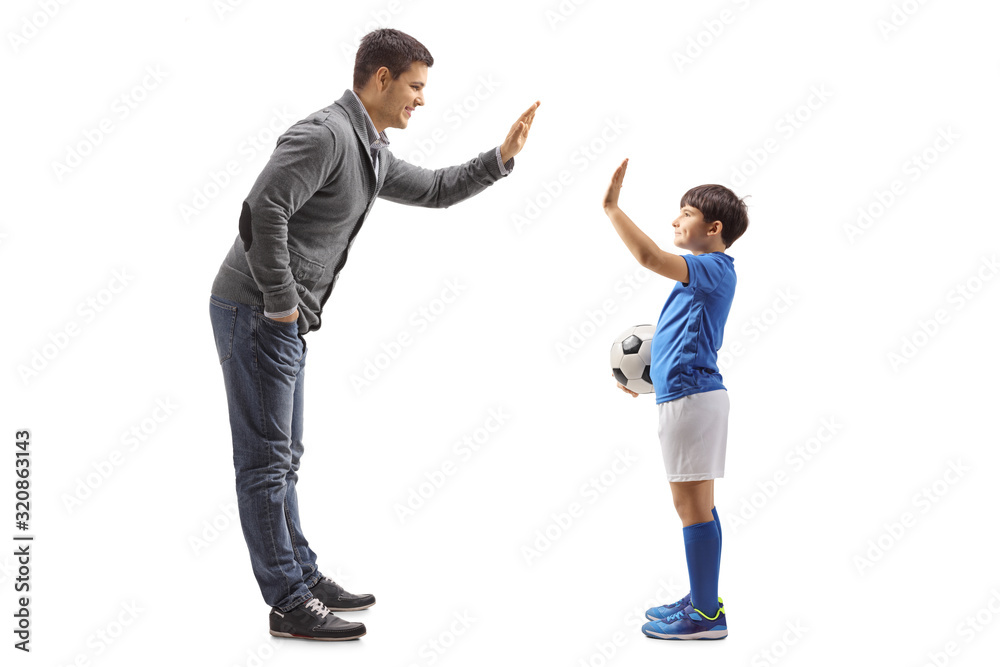 Boy with a soccer ball gesturing high five with a man