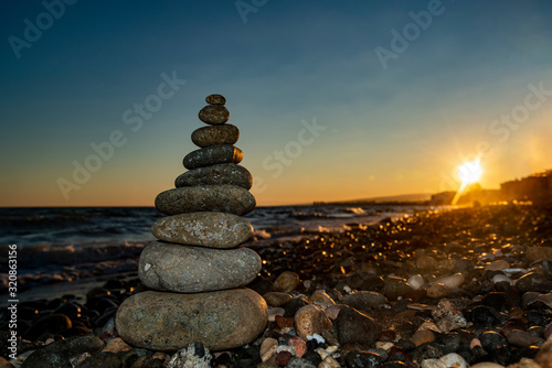 Pyramid of stones on the beach at sunset,