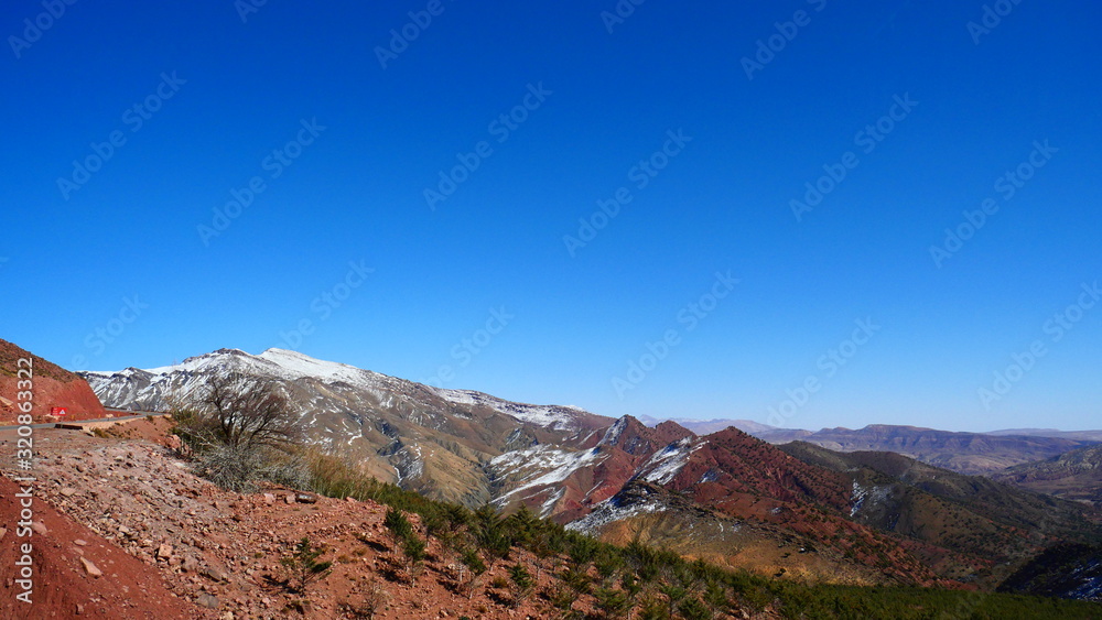 Fototapeta premium Bright landscape of Morocco, breathtaking curves of mountains, stunning combination of hills & farm land,inadvertent distribution of houses & huts, raw impression of pure nature.
