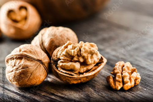 Whole walnuts on dark board, Walnut kernels in wood rustic bowl.