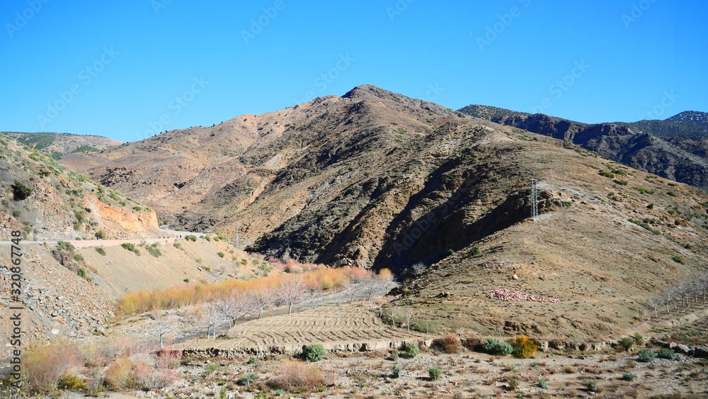 Bright landscape of Morocco, breathtaking curves of mountains, stunning combination of hills & farm land,inadvertent distribution of houses & huts, raw impression of pure nature.