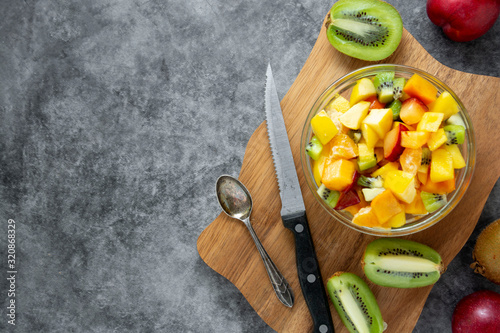 Tableau sur toile Top view of healthy fruits salad - mango, citrus, kiwi fruit, plum and persimmon