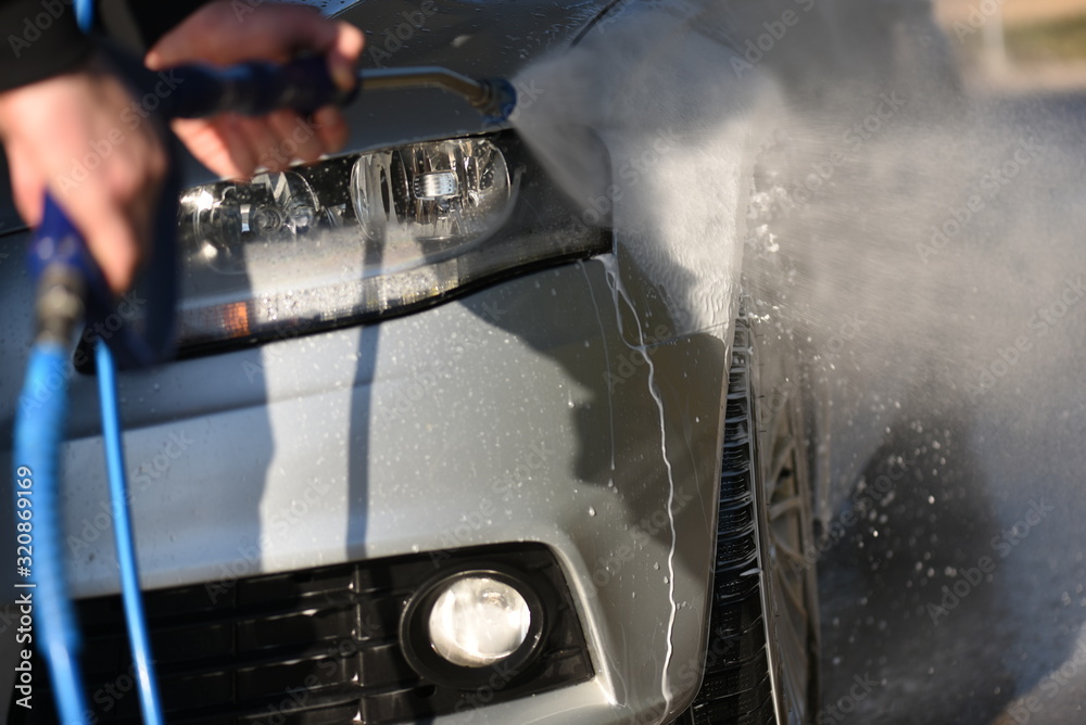 Manual car wash with pressurized water jet. Cars cleaning concept.