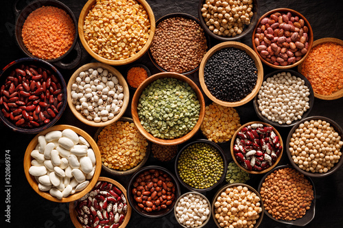 Legumes, a set consisting of different types of beans, lentils and peas on a black background, top view. The concept of healthy and nutritious food photo