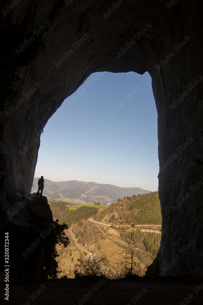 man inside a cave in basque country, spain