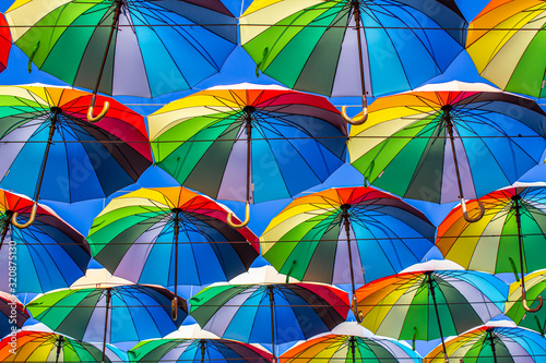 Colorful umbrellas Blue, green, red, rainbow umbrellas background Street with umbrellasin the sky Street decoration.