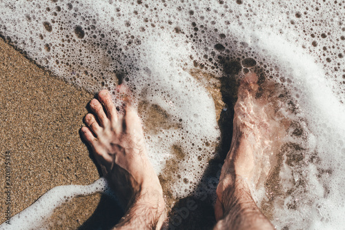Legs in the sea waves Sea beach Sea waves overlook the sandy shore