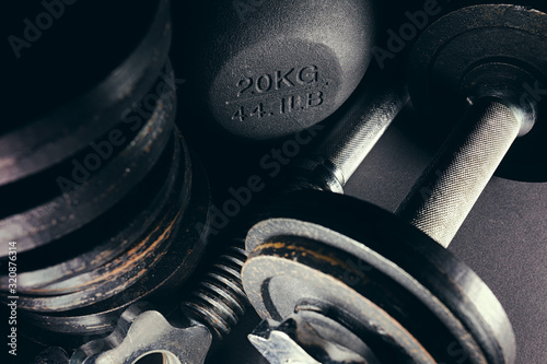 Close up of bunch of free weights and kettlebell in corner