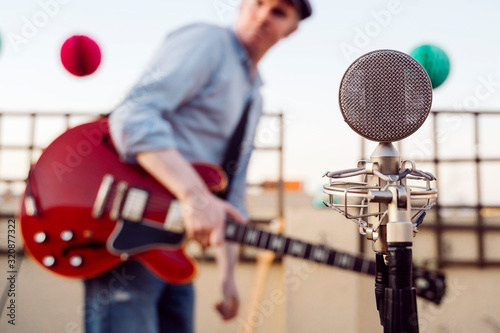 Detail of a vintage old microphone isolated on a festival background. Live music concept. Intimate concert about to start. Musicians rehearsing and testing sound conditions before performing.