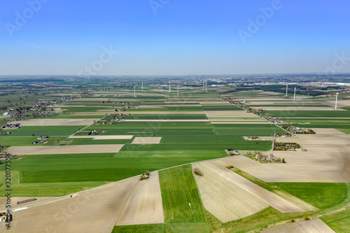 Beautiful top view of plowed and sown fields.You can see windmills on the horizon, villages and arable land that create a bizarre pattern on the ground. Shot on drone. 
