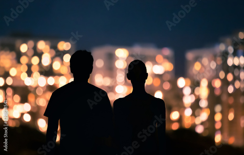 Young couple standing together looking a the city lights.  © kieferpix