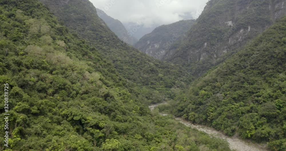Aerial view following winding river along lush green Taroko Valley jungle woodland wilderness. Aerial view following winding river along lush green Taroko Valley jungle woodland wilderness.