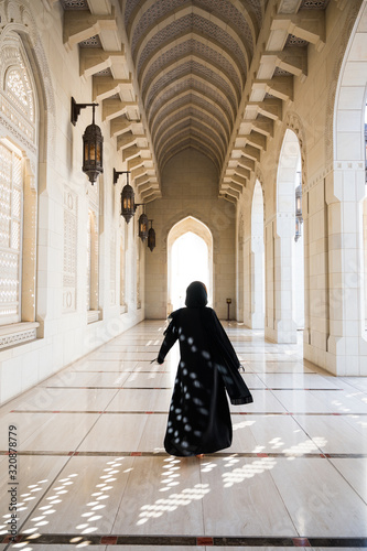 Silhouette of arabian woman in black abaya among beautiful arab architecture © ilyaska