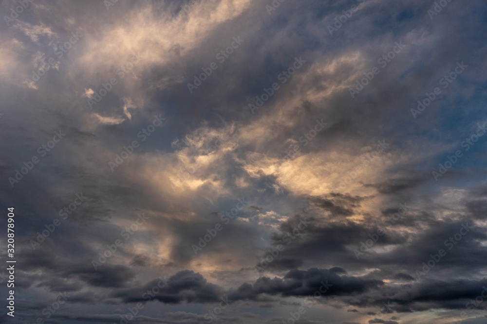 Hilo, Hawaii, USA. - January 14, 2020: Spectacular dark evening cloudscape with yellow sunlight patches.