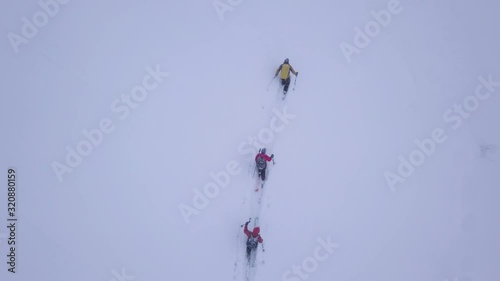 TOP DOWN, ski touring while snowing drone shot, Winter mountains sport drone shot of skiers photo