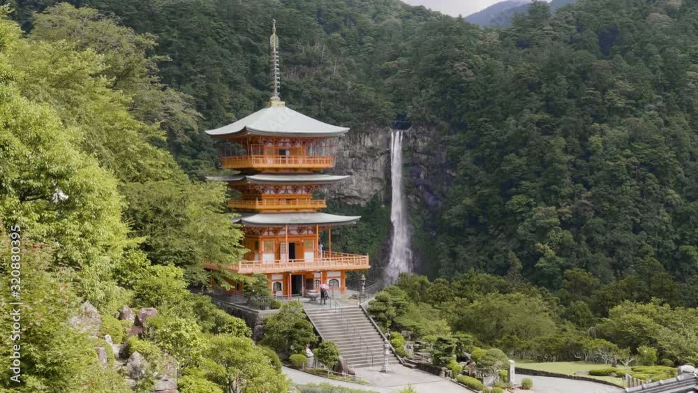 Seigantoji Temple with Nachi Falls in the background, daytime with lush green forest, static shot Seigantoji Temple with Nachi Falls in the background, daytime with lush green forest, static shot