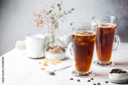 Iced coffee in a tall glasses with cream poured over