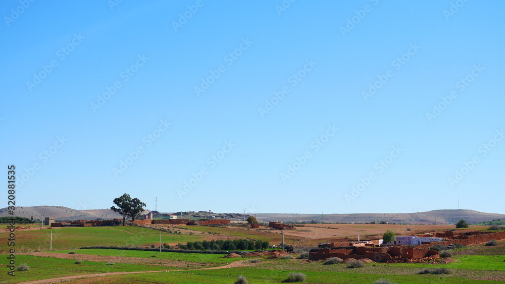 Obraz premium Bright landscape of Morocco, breathtaking curves of mountains, stunning combination of hills & farm land,inadvertent distribution of houses & huts, raw impression of pure nature.