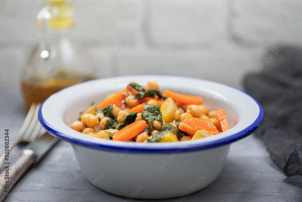 chick-pea with carrot and spinach on white bowl on ceramic backgeound