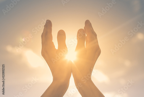 Woman the sun in her hands at dawn. Freedom and spirituality concept. 