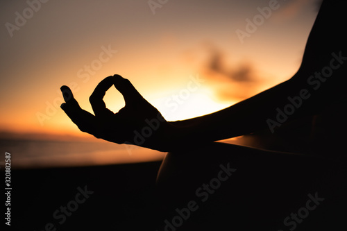 Person meditating on the beach 