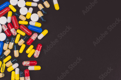 pile of multicolored tablets on a black background