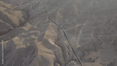 aerial shot of the desert with a small pickup truck driving on the road photo