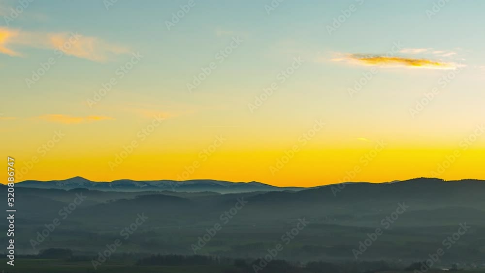 Panning time lapse of Snezka, Karkonosze mountains, during a foggy yellow sunset