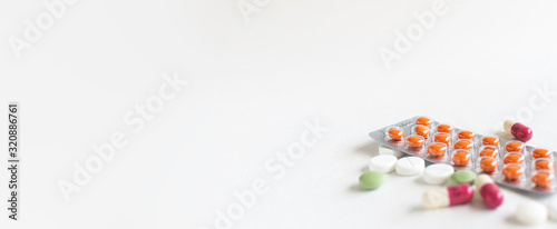 фотографія Long wide banner with colorful medical tablets and pills on white background