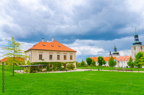 Jesuit College building and green grass lawn of Park GASK in Kutna Hora historical Town Centre, blue dramatic sky background, Central Bohemian Region, Czech Republic
