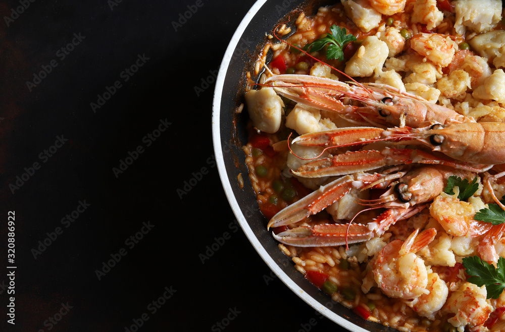 Concetto di cibo spagnolo. Paella di pesce, cibo tradizionale e tipico in Spagna con verdure fritte, riso e frutti di mare. Vista dall'alto.