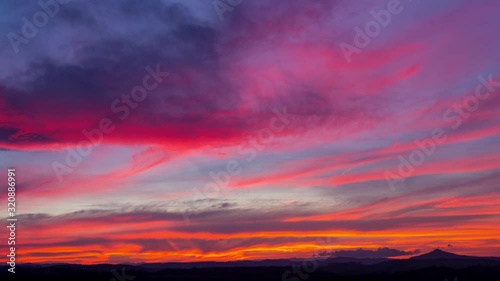 Time lapse of colorful sunset clouds over Ostrzyca Proboszczowicka mountain photo