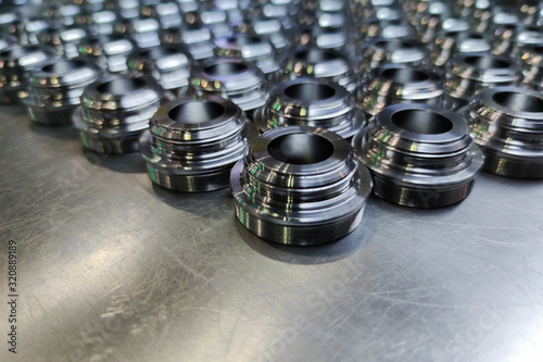 a batch of shiny metal cnc aerospace parts production - close-up with selective focus for industrial background