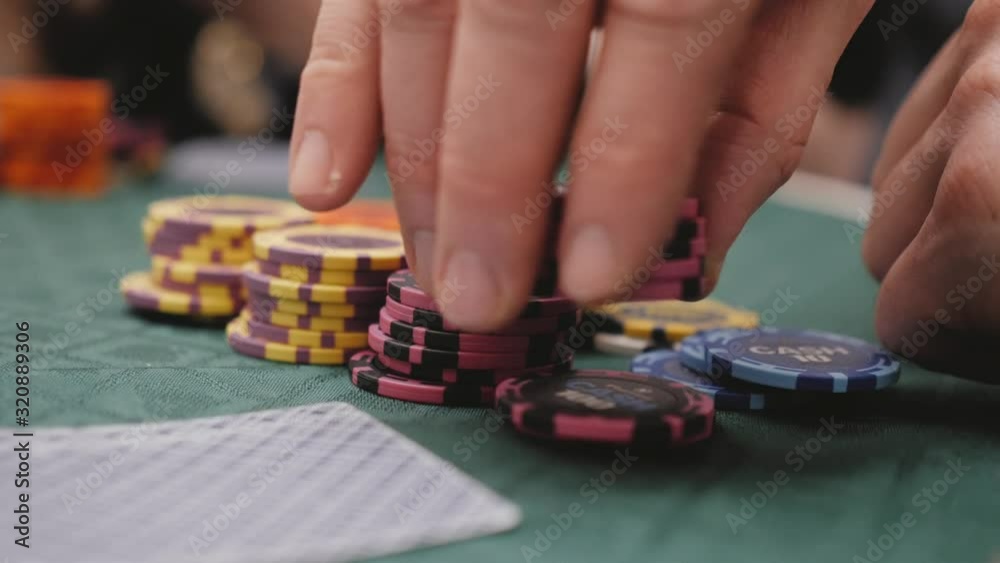 A man bets on chips while playing poker A man bets on chips while playing poker