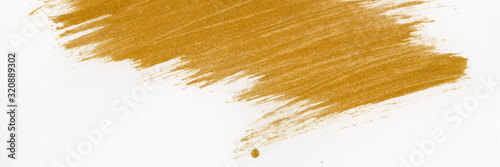 Golden traces of paint from a brush on white paper.