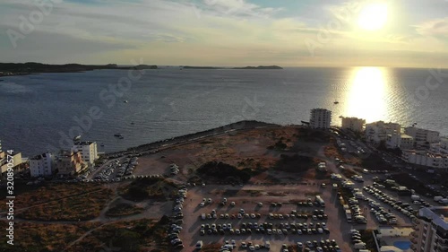 drone video of the city Sant Antoni de Portmany in ibiza overflying the center paning left to the port during golden hour photo